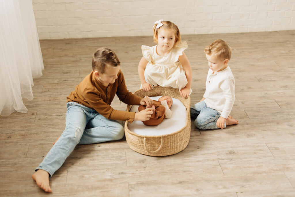 siblings play with new baby brother in a utah county lifestyle session