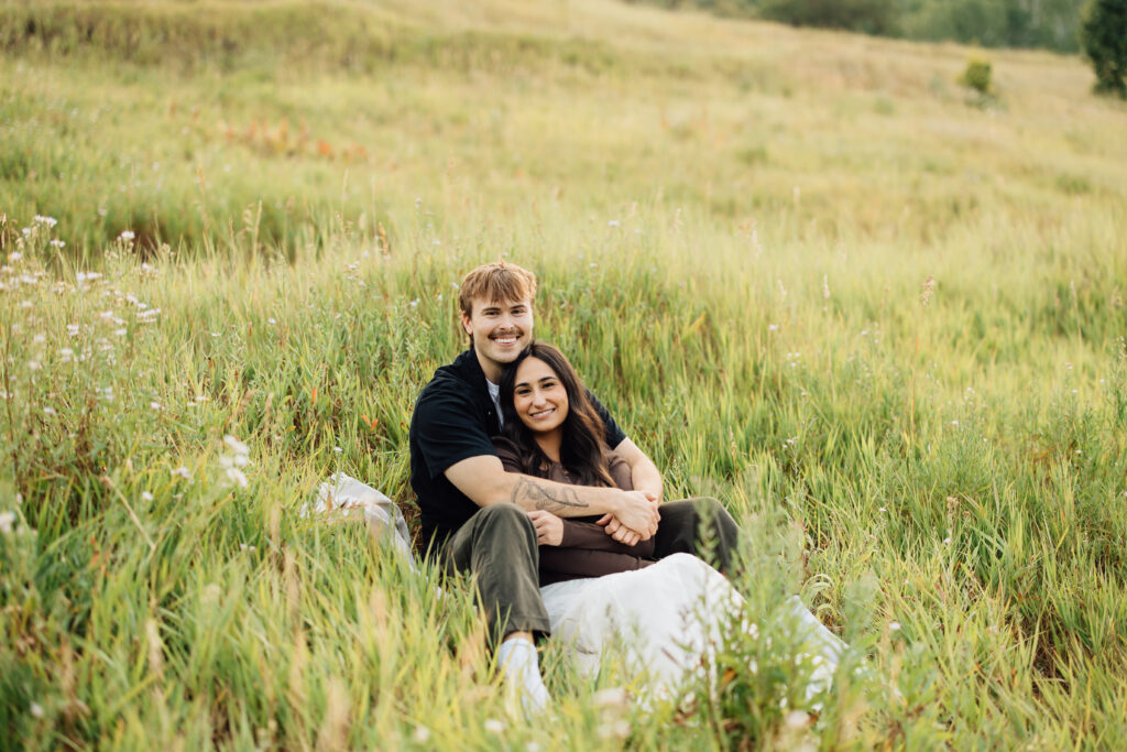 Couple smiles in the tall grasses at Buffalo Peak in their Provo Engagement Session
