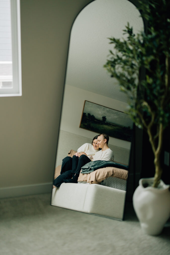 Mom and Dad cuddle baby in lifestyle newborn session in Saratoga Springs