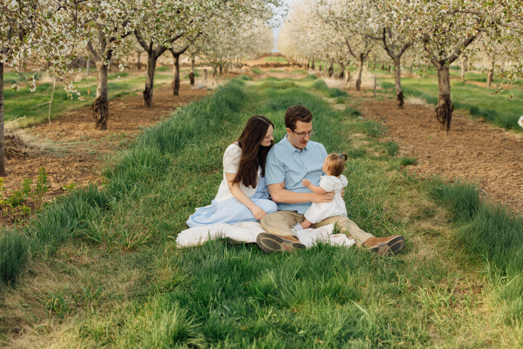 Family smiles in spring orchard blossom mini session