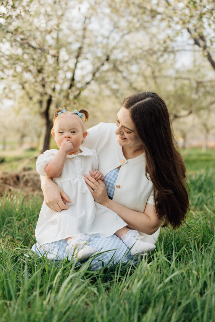 Mother and baby smile in orchard blossom photo session